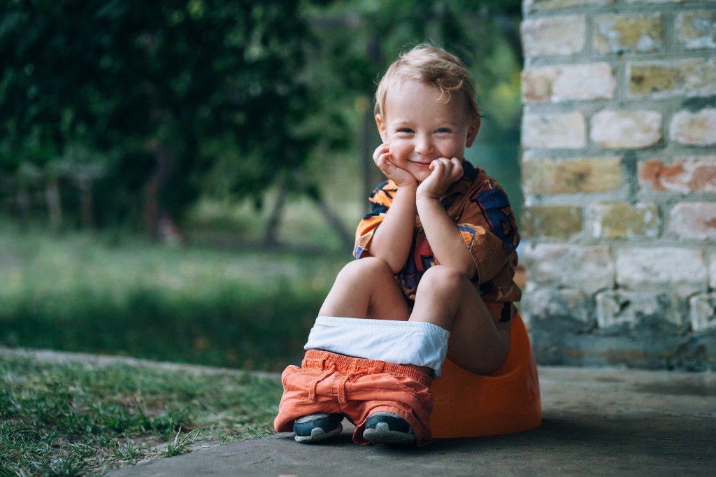 A toddler seen potty training with their diapers down.