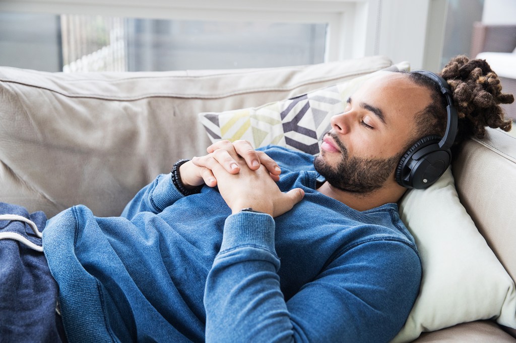 a man lying on a couch with headphones on