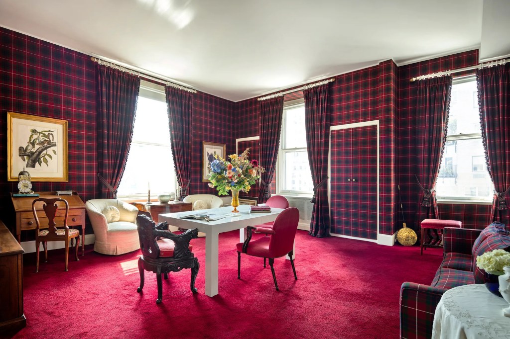 Sitting roo m with red plaid wallpaper and curtains, red carpet, white chairs and a table and chairs.