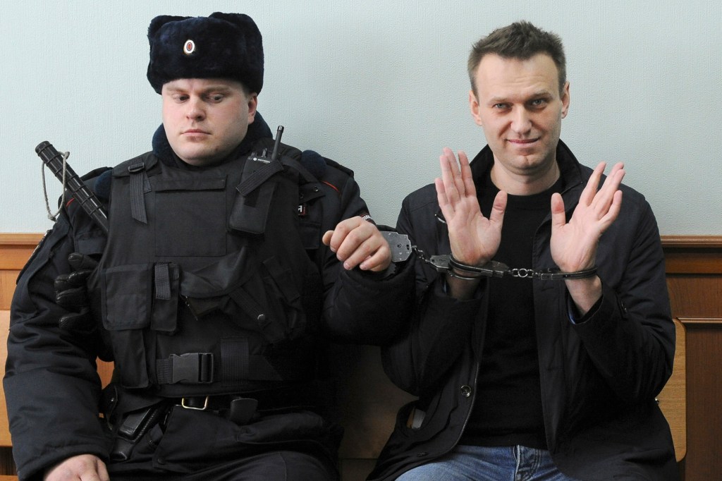 A man sitting in a court with handcuffs on his hands, identified as Alexei Navalny, the Russian opposition leader.