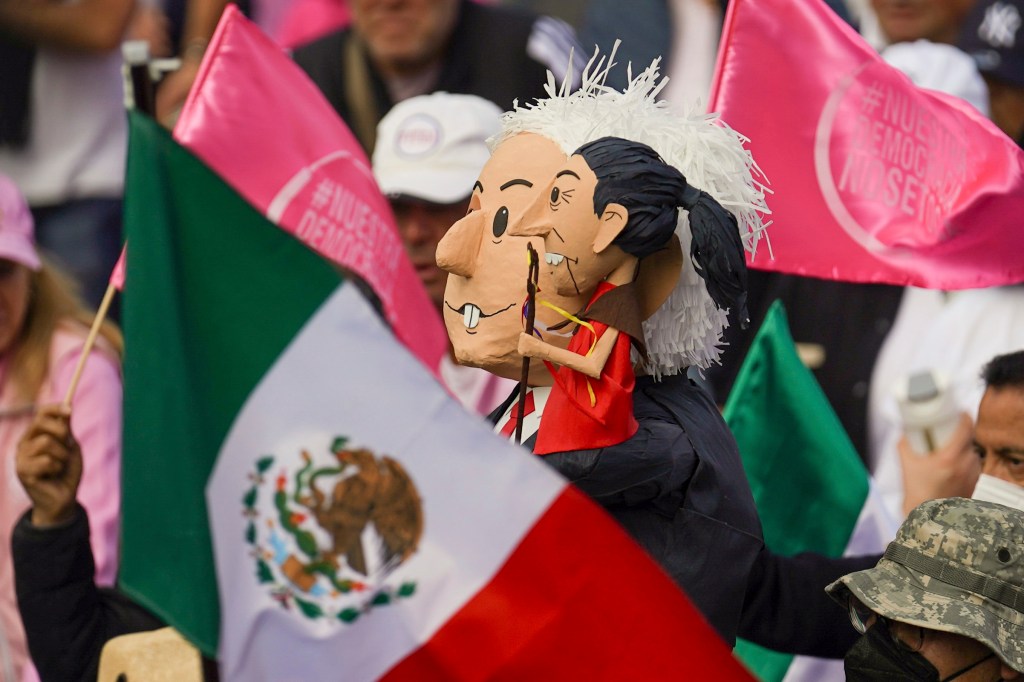 Protestors carrying puppets portraying Mexican President Andres Manuel Lopez Obrador and presidential candidate Claudia Sheinbaum.