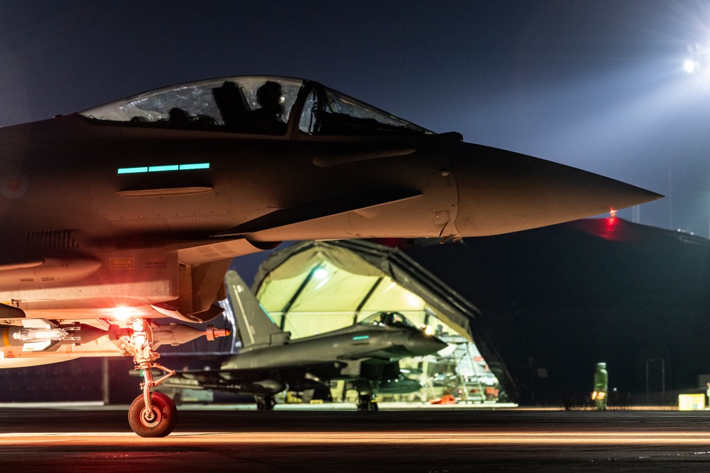 A Royal Air Force Typhoon aircraft on a runway at night, preparing for strikes against Houthi targets in Yemen.