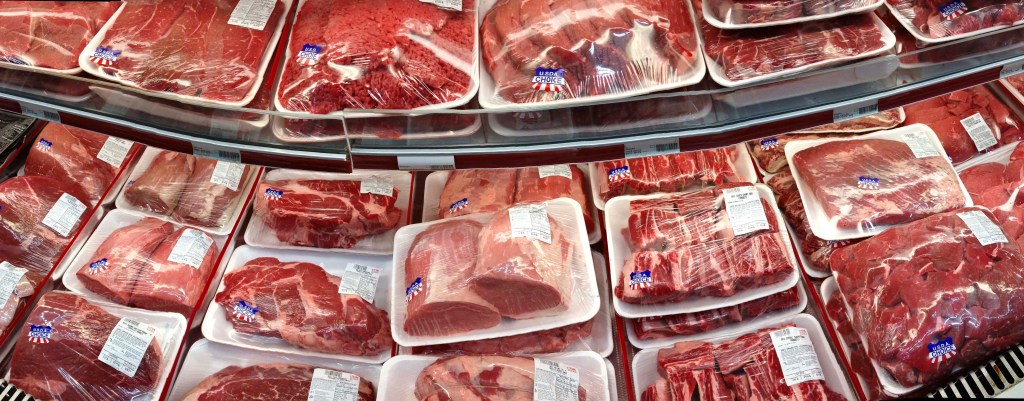 Various cuts of beef and pork in plastic wrap on a shelf at a discount market in Arlington, VA.