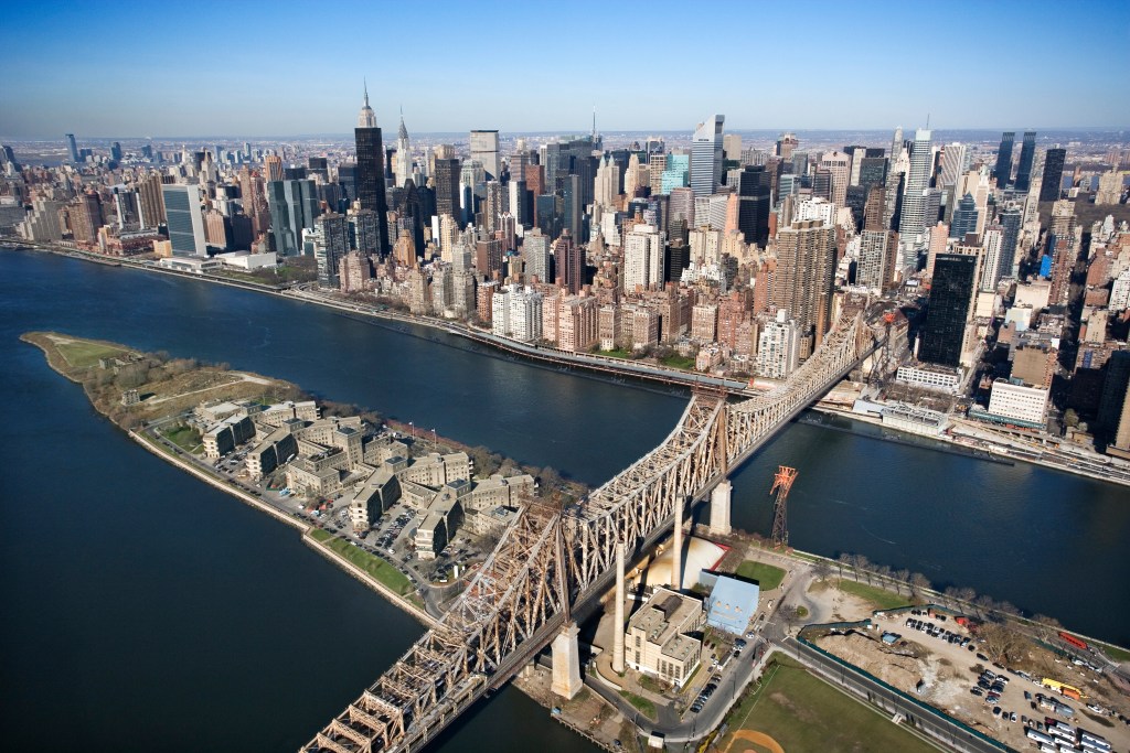 Aerial view of Queensboro Bridge in New York City with Rooseveldt Island and  Manhattan cityscape.