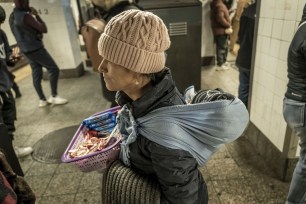 An Ecuadorean migrant, wearing her baby on her back, sold candy to passengers at Grand Central Station on a recent afternoon.