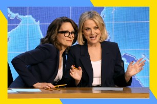 Tina Fey (L) and Amy Poehler sit behind the Weekend Update desk at the Emmys.
