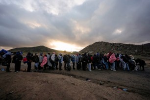 Asylum seekers stand in line at a makeshift campsite in the mountains near Jacumba Hot Springs, California, after crossing the border.