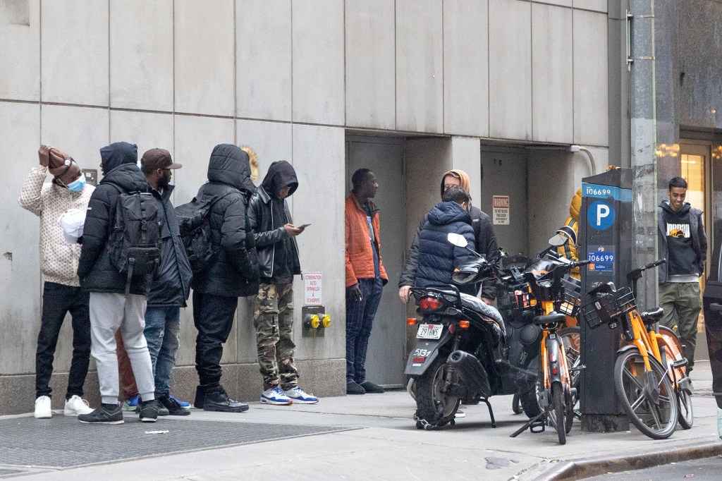 Migrants standing outside the entrance to the Candler building on 41st St. in New York City.