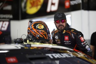 Martin Truex Jr., driver of the No. 19 Bass Pro Shops Toyota, enters his car in the garage area during practice for the NASCAR Cup Series Daytona 500.