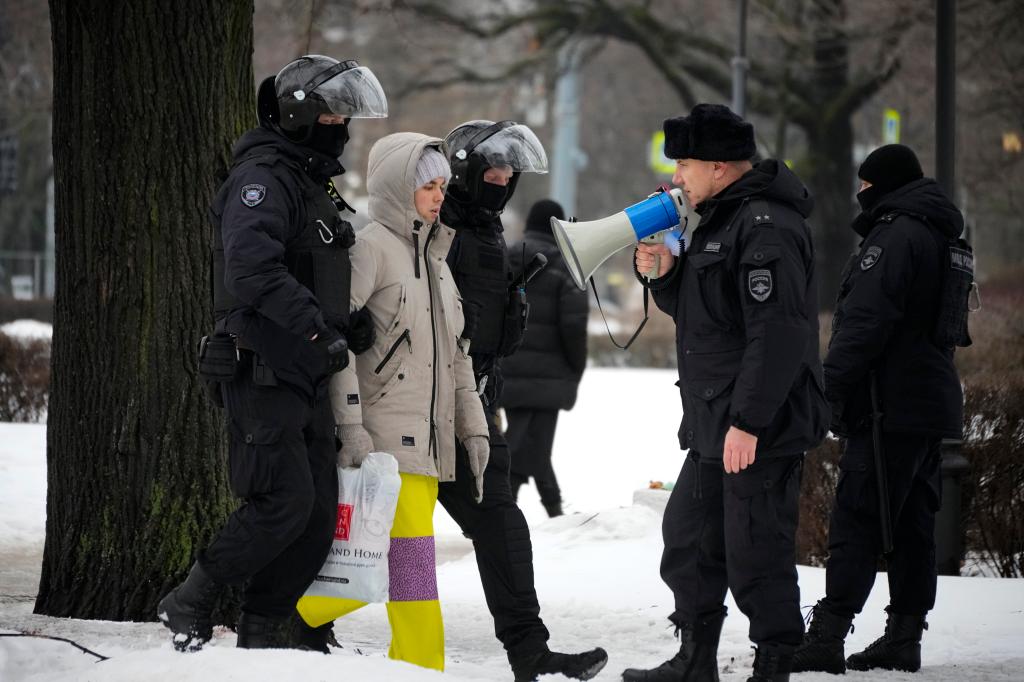 Police detain a man as he wanted to lay flowers paying their last respect to Alexei Navalny at the monument