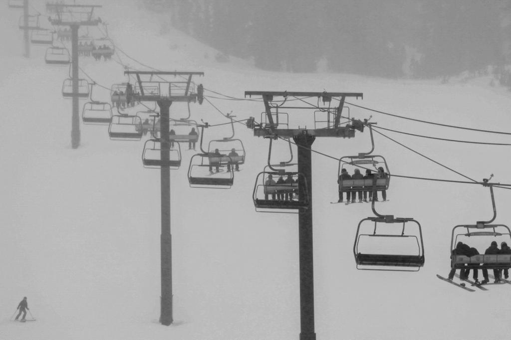 skiers ride a lift during a snowfall at Mammoth Mountain Ski Area in Mammoth Lakes, Calif., on Saturday, Jan. 13, 2024.