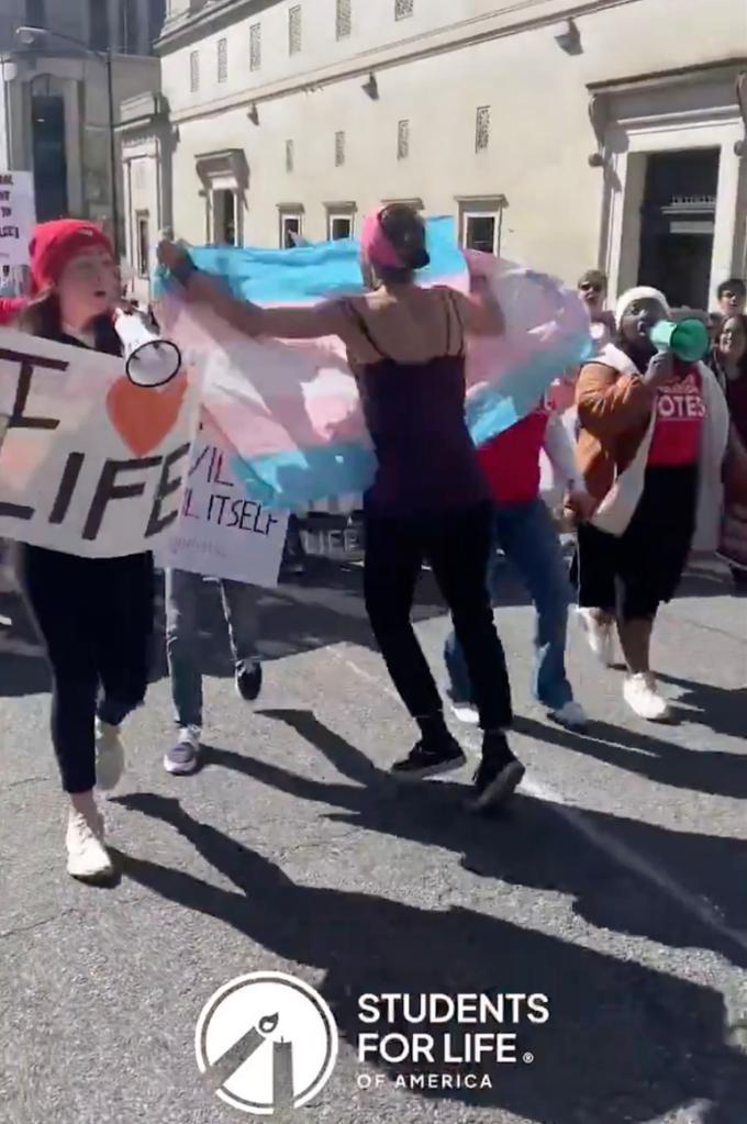 Noah Cleveland, 42, is seen running into a group of pro-life students holding a transgender flag.