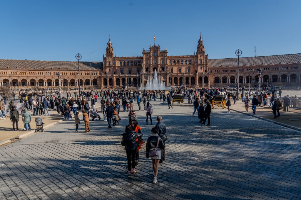 Warm people around the Plaza de España, on a cold and sunny day on December 27, 2023 in Seville.