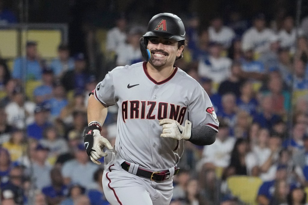 Diamondbacks' Corbin Carroll smiles as he rounds the bases after hitting a home run