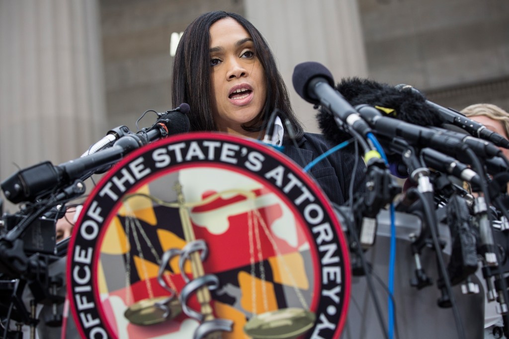Marilyn J. Mosby speaking into microphones to announce criminal charges against Baltimore police officers in Freddie Gray's death.