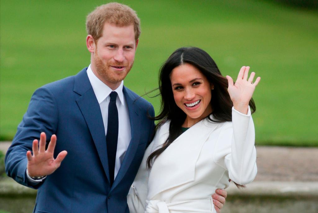 Prince Harry and Meghan Markle posing for a photo in a garden.