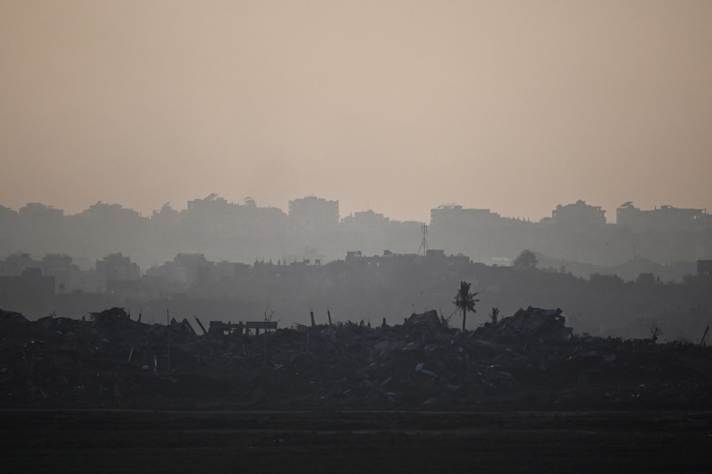 A wide photo shows an uncountable number of buildings in Gaza in reduced to rubble.