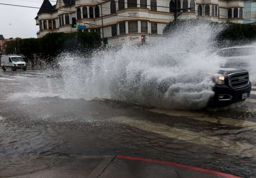 Cars drive on flooded streets, during the ongoing rain storm in Studio City, California