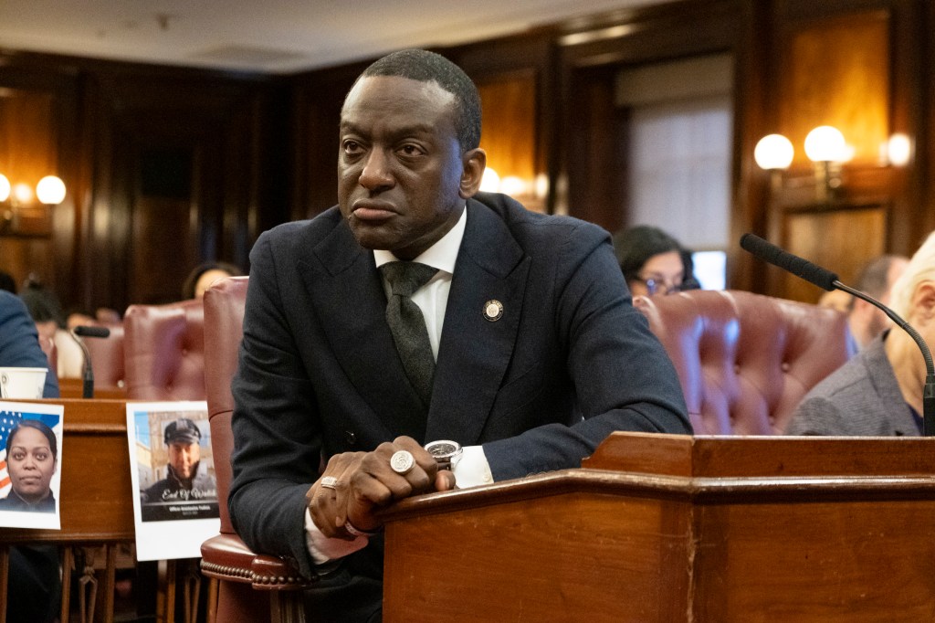 City Council Member Yesef Salaam sitting at a podium in a suit at City Hall in Manhattan. 