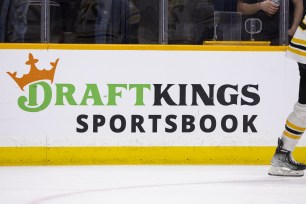 Detail view of a DraftKings Sportsbook ad as Boston Bruins players skate in warm-ups prior to the game against the Nashville Predators.