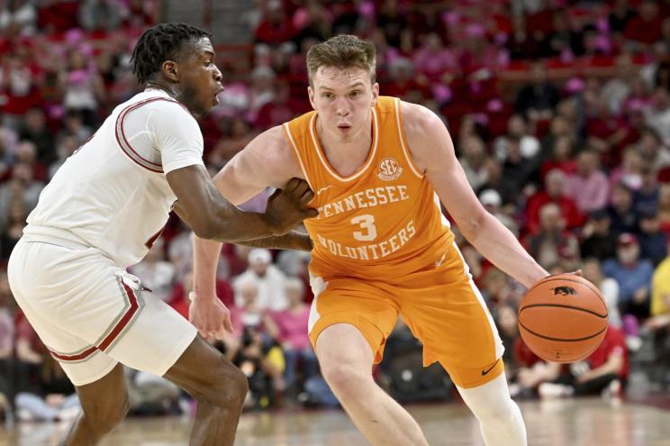 Tennessee guard Dalton Knecht (3) drives against Arkansas guard Davonte Davis (4) during the first half of an NCAA college basketball game Wednesday, Feb. 14, 2024, in Fayetteville, Ark.