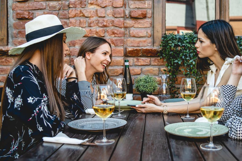 Group of Caucasian women female friends sitting at the table at restaurant having a discussion.