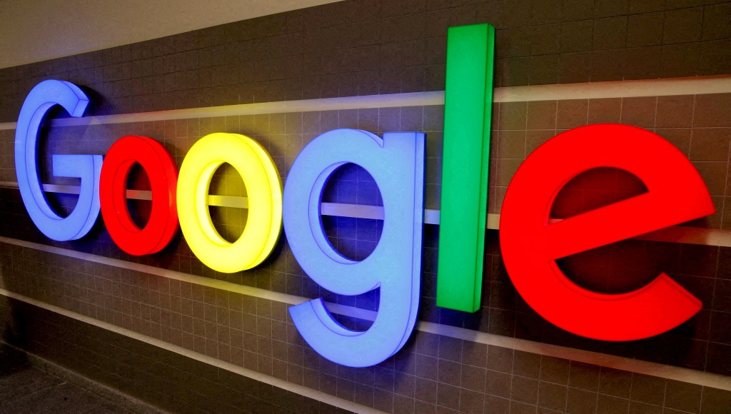 An illuminated Google logo against a dark background.