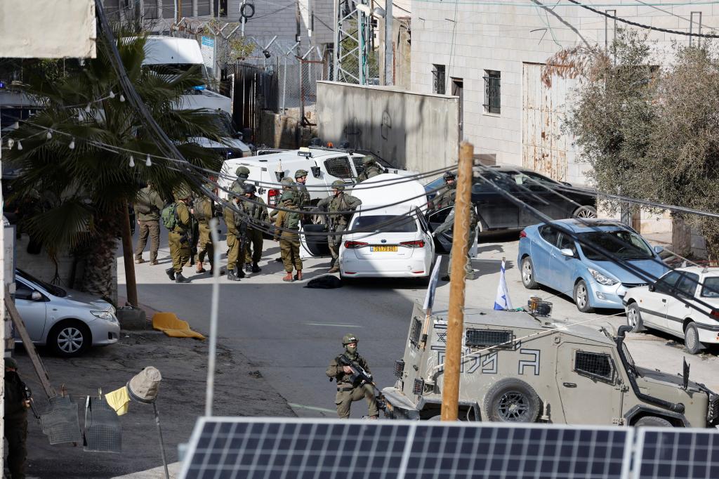 Israeli troops stand guard near a shooting scene in Hebron in the Israeli-occupied West Bank February 1, 2024. 