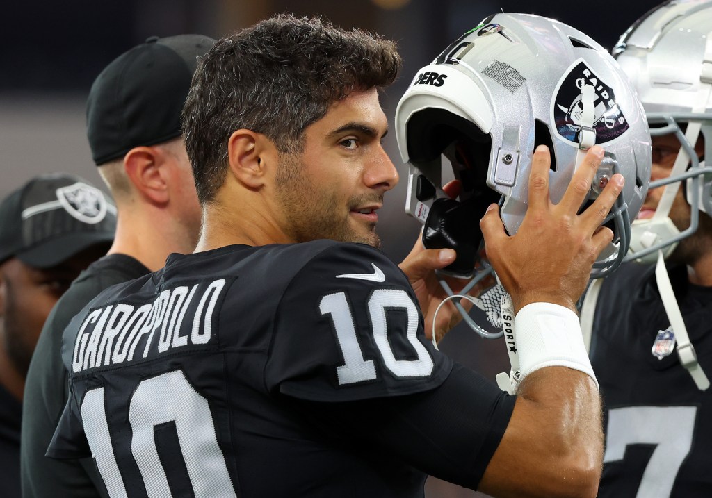 Jimmy Garoppolo wearing a helmet and warming up before Las Vegas Raiders play the Dallas Cowboys preseason game in AT&T Stadium.