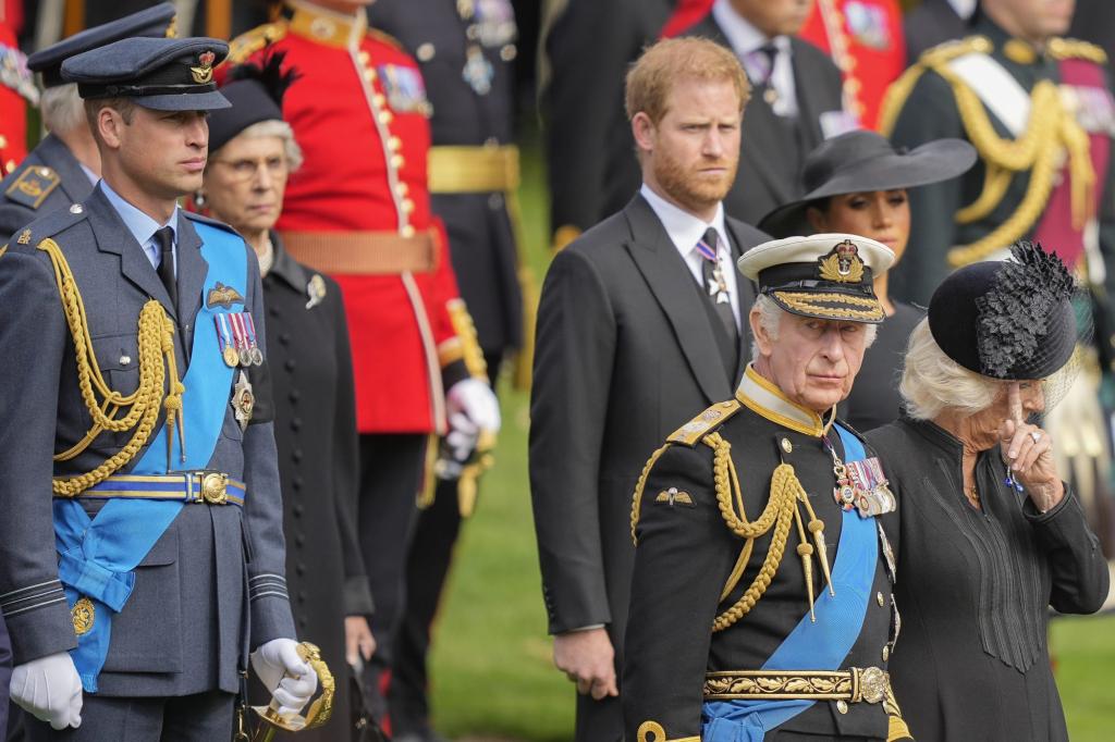 King Charles III, Camilla, Prince Harry, and Prince William in military uniforms watch as Queen Elizabeth II's coffin is placed into the hearse.