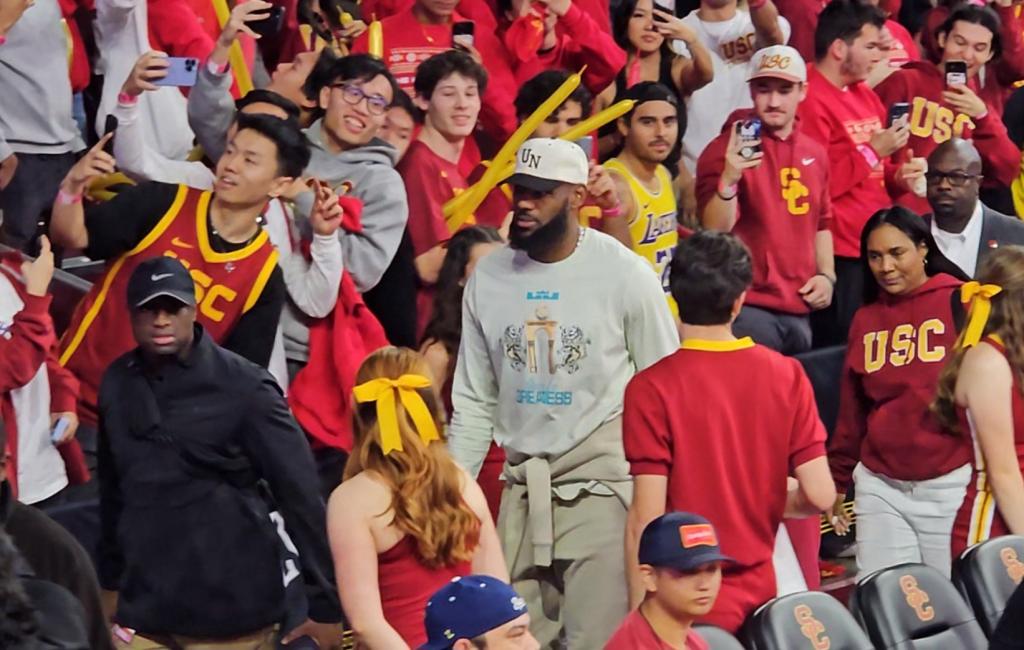 LeBron James leads hid family through massive student filled crowd as they watched Bronny James' first college basketball game.