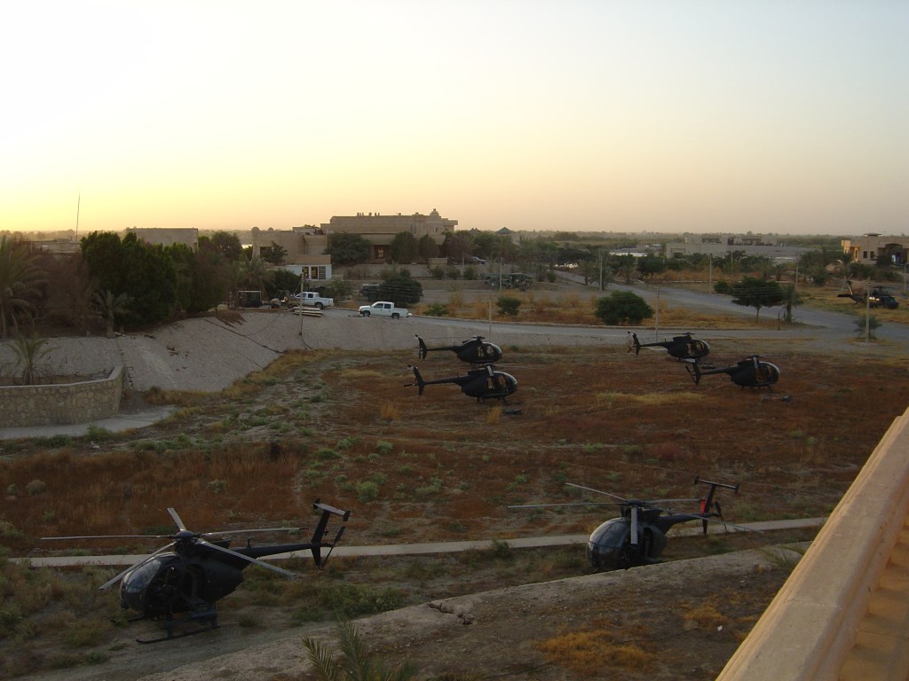 A field with six H-6M Little Bird helicopters. 