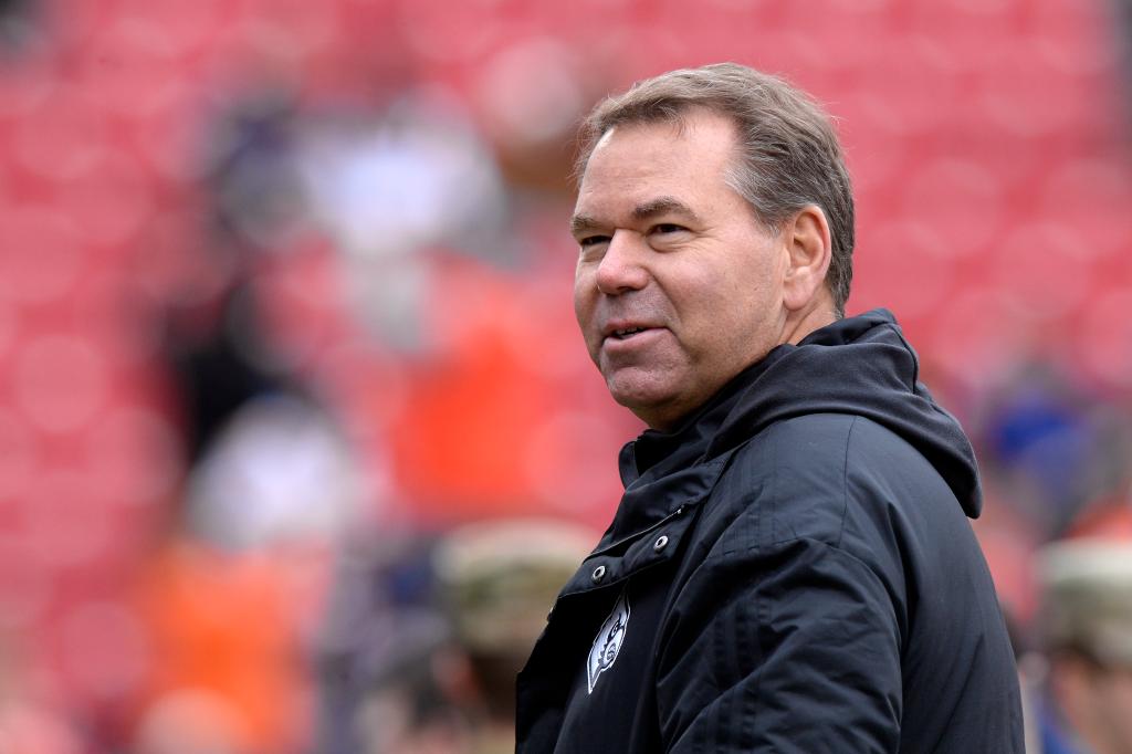 Vince Tyra standing and watching football game.