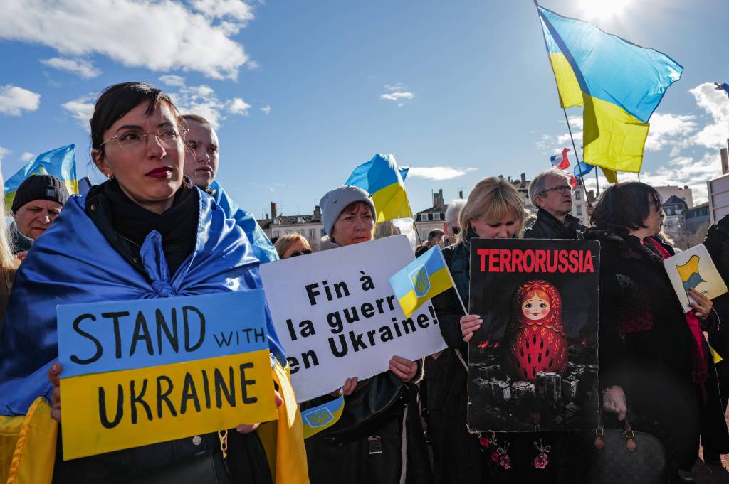 People gather in support of Ukrainian people, holding signs, in Place Bellecour in Lyon, France - February 24, 2024.