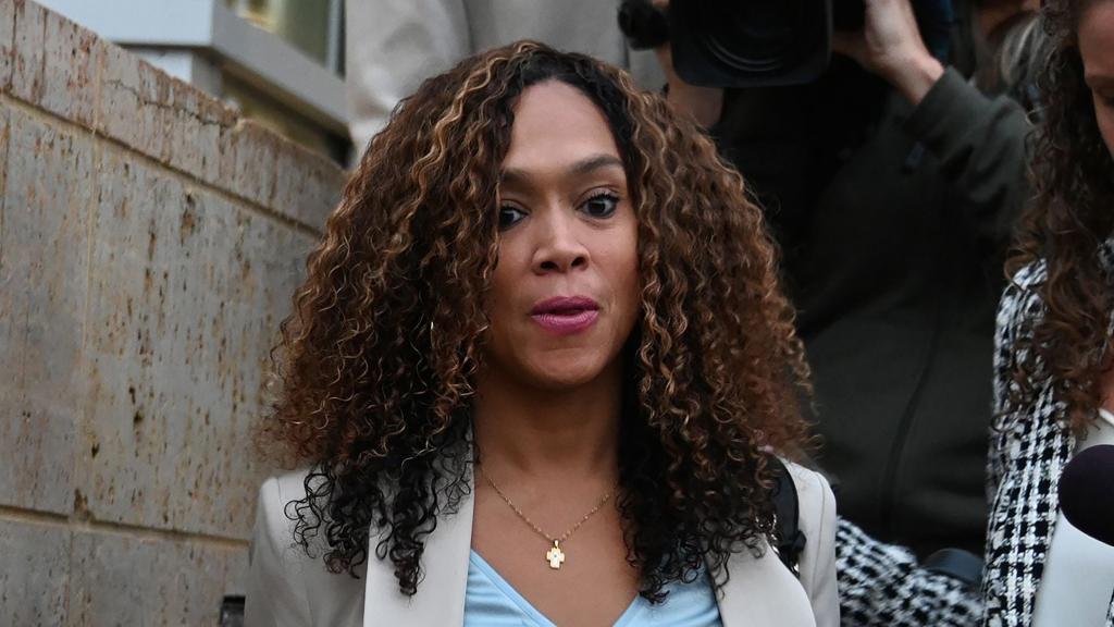 Marilyn Mosby, a woman with curly hair and a cross necklace, leaves a courthouse in Greenbelt, Maryland after being found guilty of perjury charges.