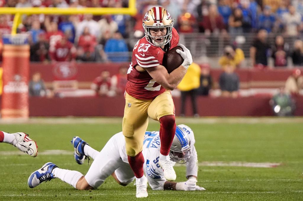 San Francisco 49ers running back Christian McCaffrey (23) runs in front of Detroit Lions defensive end Romeo Okwara during the second half of the NFC Championship NFL football game in Santa Clara, Calif., Sunday, Jan. 28, 2024. 