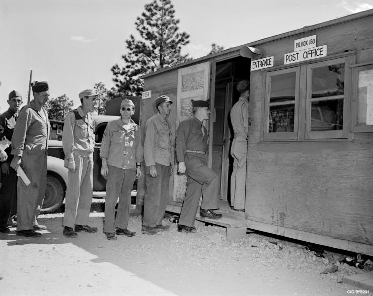 Men lined up at the entrance of a post office.