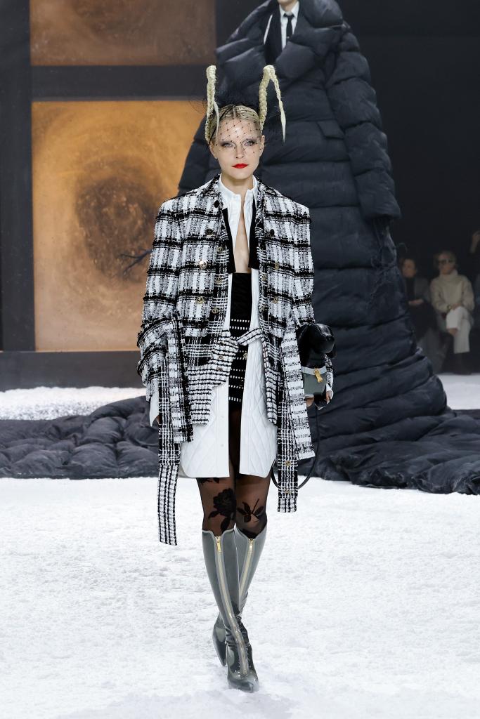 A model walks a runway, wearing a black and white coat during the Thom Browne Fall 2024 fashion show at New York Fashion Week.