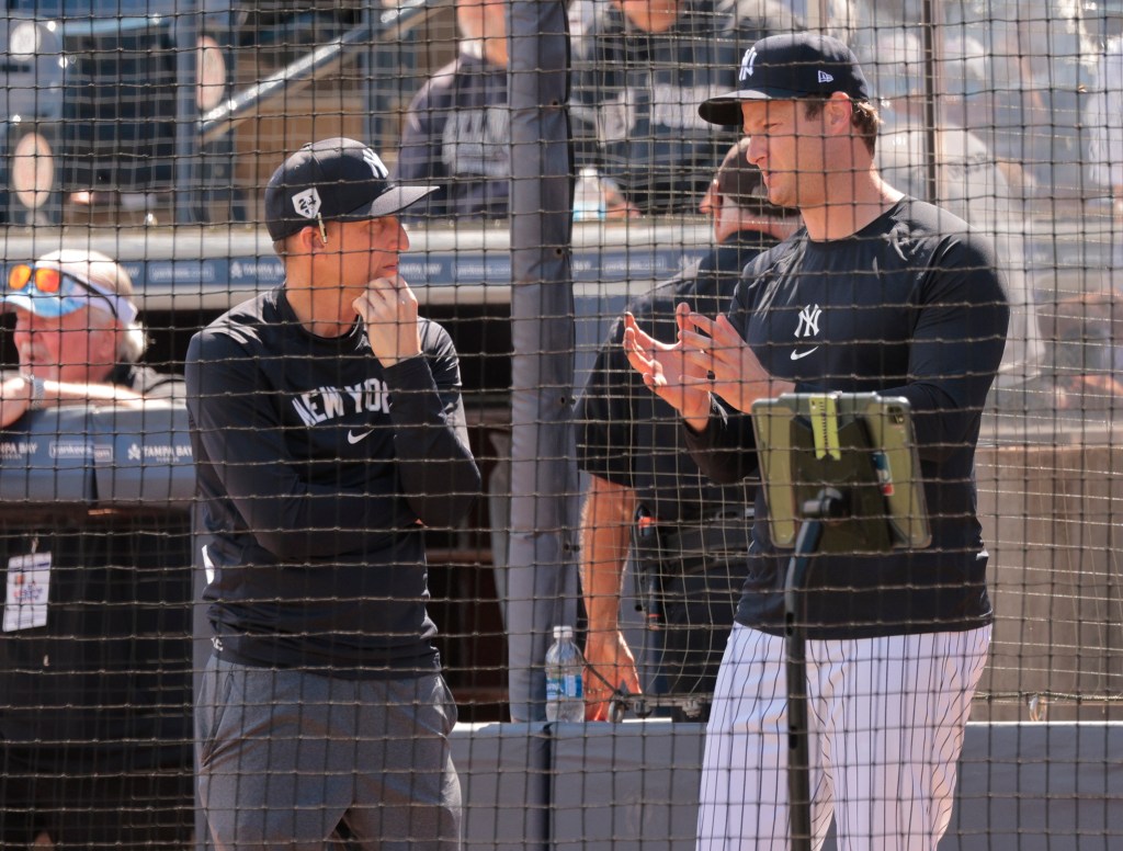 Yankees major-league coaching staff analyst Aaron Leanhardt speaking with pitcher Gerrit Cole during practice