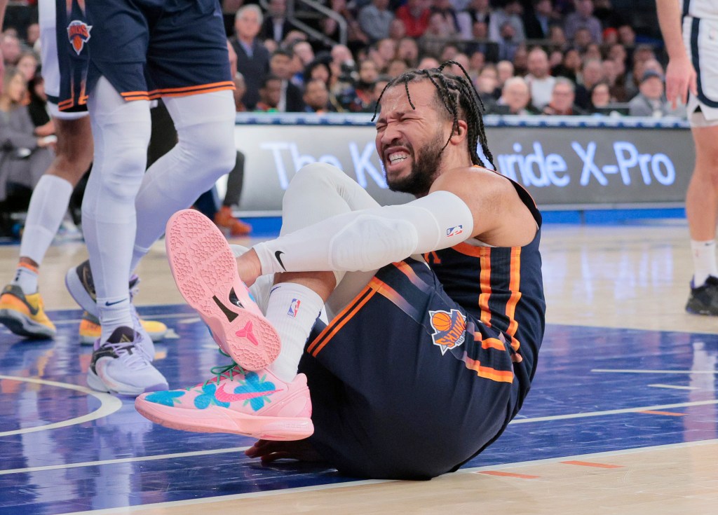 Jalen Brunson hold his ankle before leaving the game with an injury late in the Knicks' win over the Grizzlies on Tuesday night.