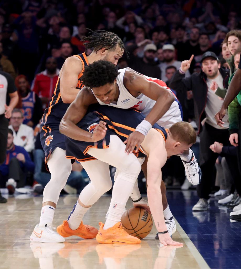 Donte DiVincenzo (0) and Jalen Brunson (11) rush for a loose ball along with Detroit Pistons forward Ausar Thompson (9) in the final seconds.