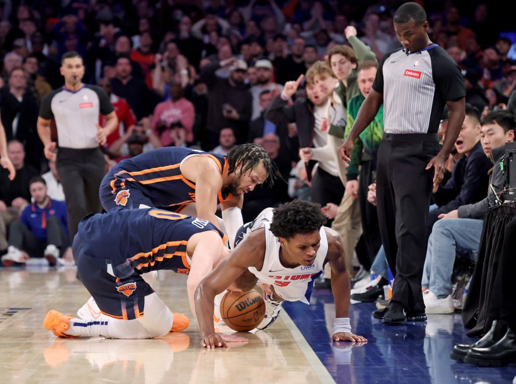 Donte DiVincenzo and guard Jalen Brunson (11) rush for a loose ball along with Detroit Pistons forward Ausar Thompson during the fourth quarter on Monday.
