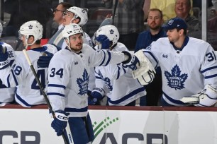 Auston Matthews celebrates with teammates after scoring his 50th goal during the Maple Leafs' win.