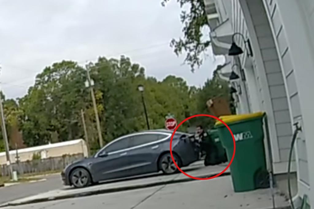 Officer seen kneeling behind car
