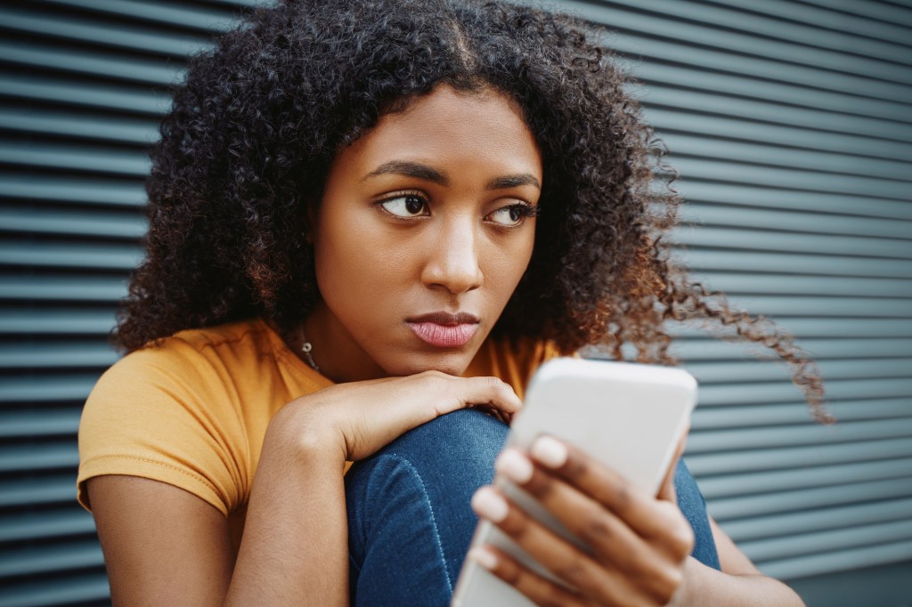 A black woman using a cellphone.