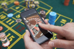 Person playing free roulette online over a roulette table