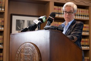 Oregon Gov. Tina Kotek listens to a reporter ask a question during a news conference.