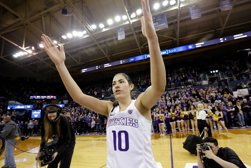 Basketball player Kelsey Plum smiling and waving to fans after breaking the all-time career NCAA scoring record.