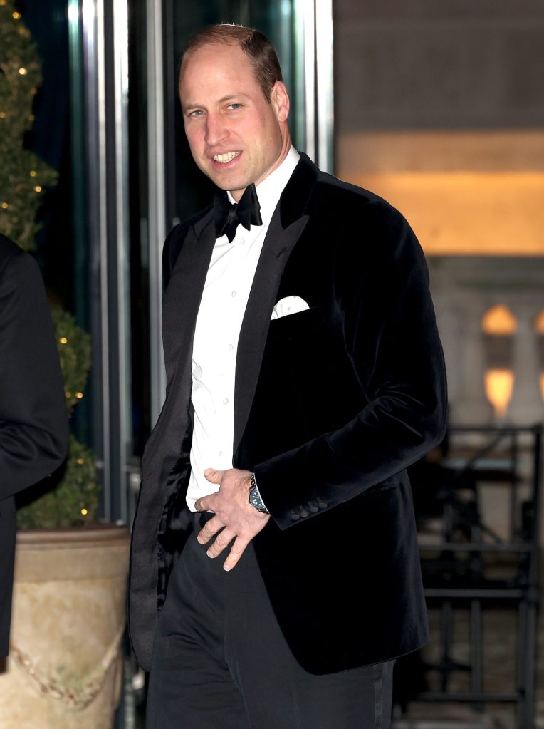 Prince William, Prince of Wales in a tuxedo waving during a charity gala dinner event.