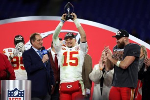 Patrick Mahomes celebrates with the Lamar Hunt Trophy as Jim Nantz looks on after a 17-10 victory against the Baltimore Ravens in the AFC Championship.